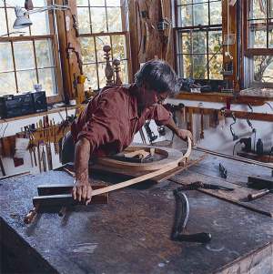 Ainley bends the bows for bow-back chairs after it has been softened by steam. 