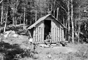 William C. Noble, fire observer, sitting in the doorway of his cabin.  